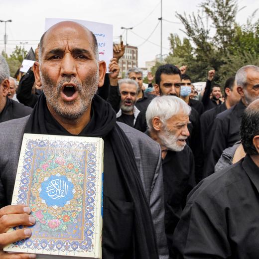 A protester chants slogans while marching with a copy of the Koran, Islam's holy book, during a demonstration against the burning of the Koran in Sweden, after the weekly Muslim Friday prayers at Mosalah mosque in Tehran on July 21 2023. (Photo by AFP)