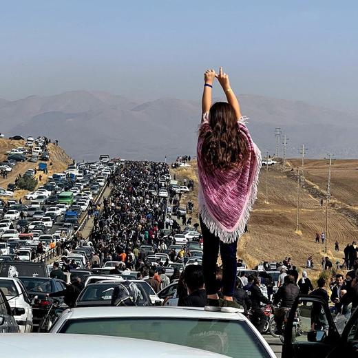 (FILES) This UGC image posted on Twitter on October 26, 2022 reportedly shows an unveiled woman standing on top of a vehicle as thousands make their way towards Aichi cemetery in Saqez, Mahsa Amini's home town in the western Iranian province of Kurdistan, to mark 40 days since her death, defying heightened security measures as part of a bloody crackdown on women-led protests. Many Iranian Kurds fled to Iraq, some on tourist visas. The dire economic situation in sanctions-hit Iran has compelled many to seek work in Iraq. (Photo by UGC / AFP) / === RESTRICTED TO EDITORIAL USE - MANDATORY CREDIT "AFP PHOTO / UGC IMAGE" - NO MARKETING NO ADVERTISING CAMPAIGNS - DISTRIBUTED AS A SERVICE TO CLIENTS FROM ALTERNATIVE SOURCES, AFP IS NOT RESPONSIBLE FOR ANY DIGITAL ALTERATIONS TO THE PICTURE'S EDITORIAL CONTENT, DATE AND LOCATION WHICH CANNOT BE INDEPENDENTLY VERIFIED === / TO WITH: Iran-protest-women-rights-iraq-Kurds- FOCUS by Layal SHAKIR