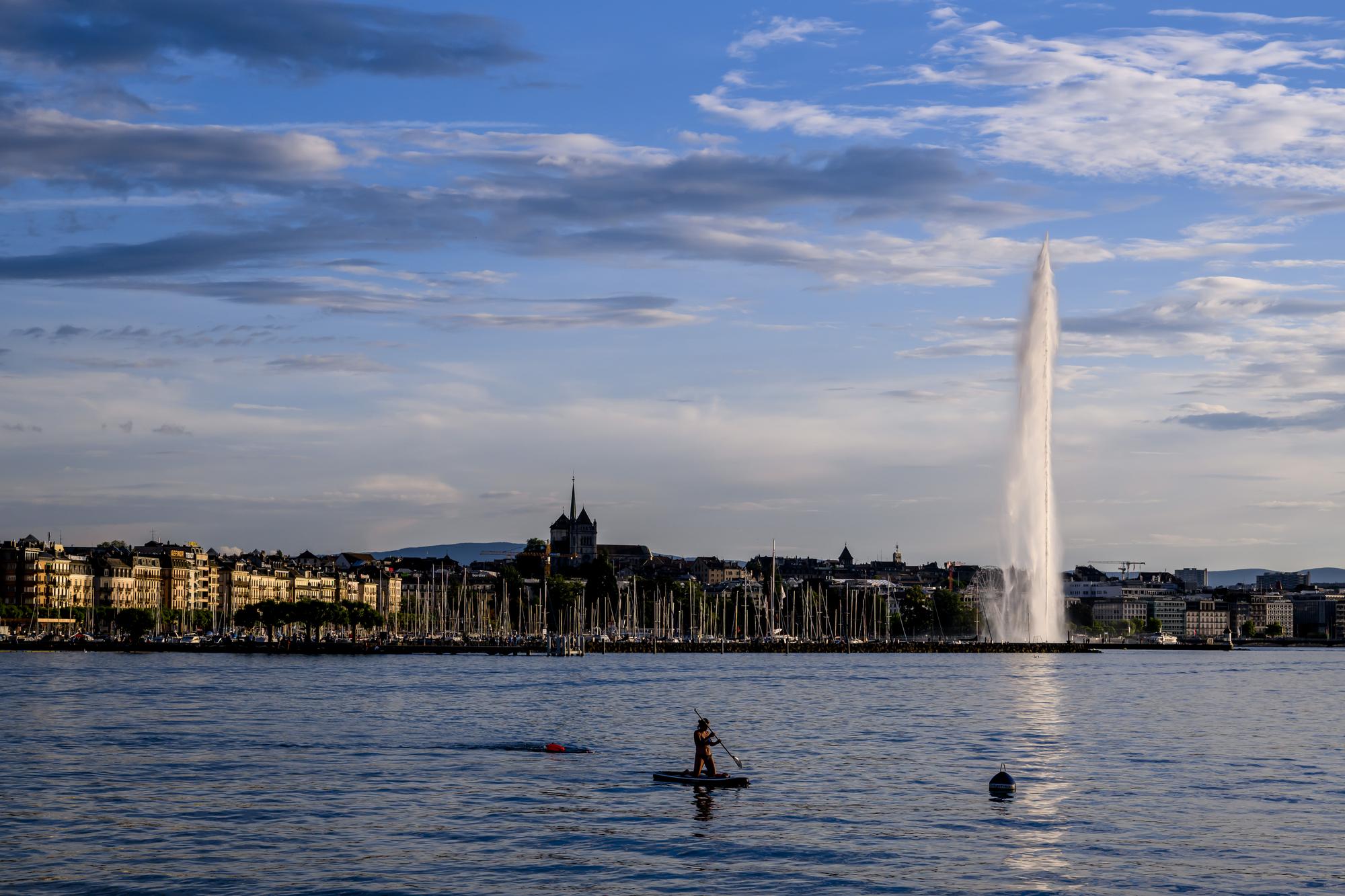 Une personne pratique le paddle devant le Jet d'eau dans la rade de Geneve lorsque le soleil se couche le samedi 10 juin 2023 a Geneve. (KEYSTONE/Jean-Christophe Bott)