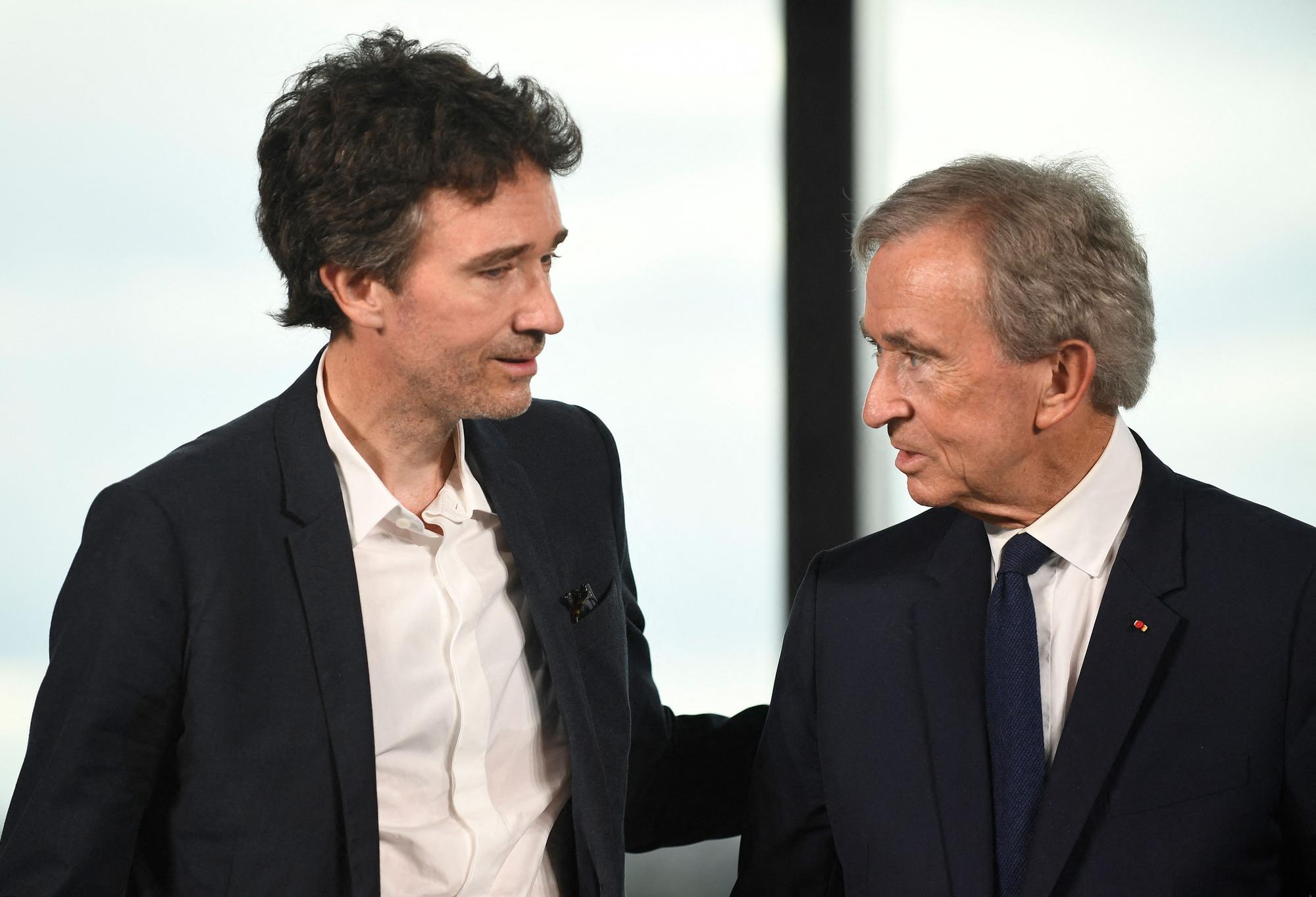 CEO of LVMH Holding Company, Antoine Arnault (L) and World's top luxury group LVMH head Bernard Arnault talk during a meeting after LVMH was named as final premium sponsor of 2024 Paris Olympics, in Paris on July 24, 2023. LVMH group announced on July 24, 2023, that it was the sixth premium partner for the Paris 2024 Olympic Games, allowing the comittee to almost reach their objective of 1.24 billion euros in partnerships. (Photo by JULIEN DE ROSA / AFP)