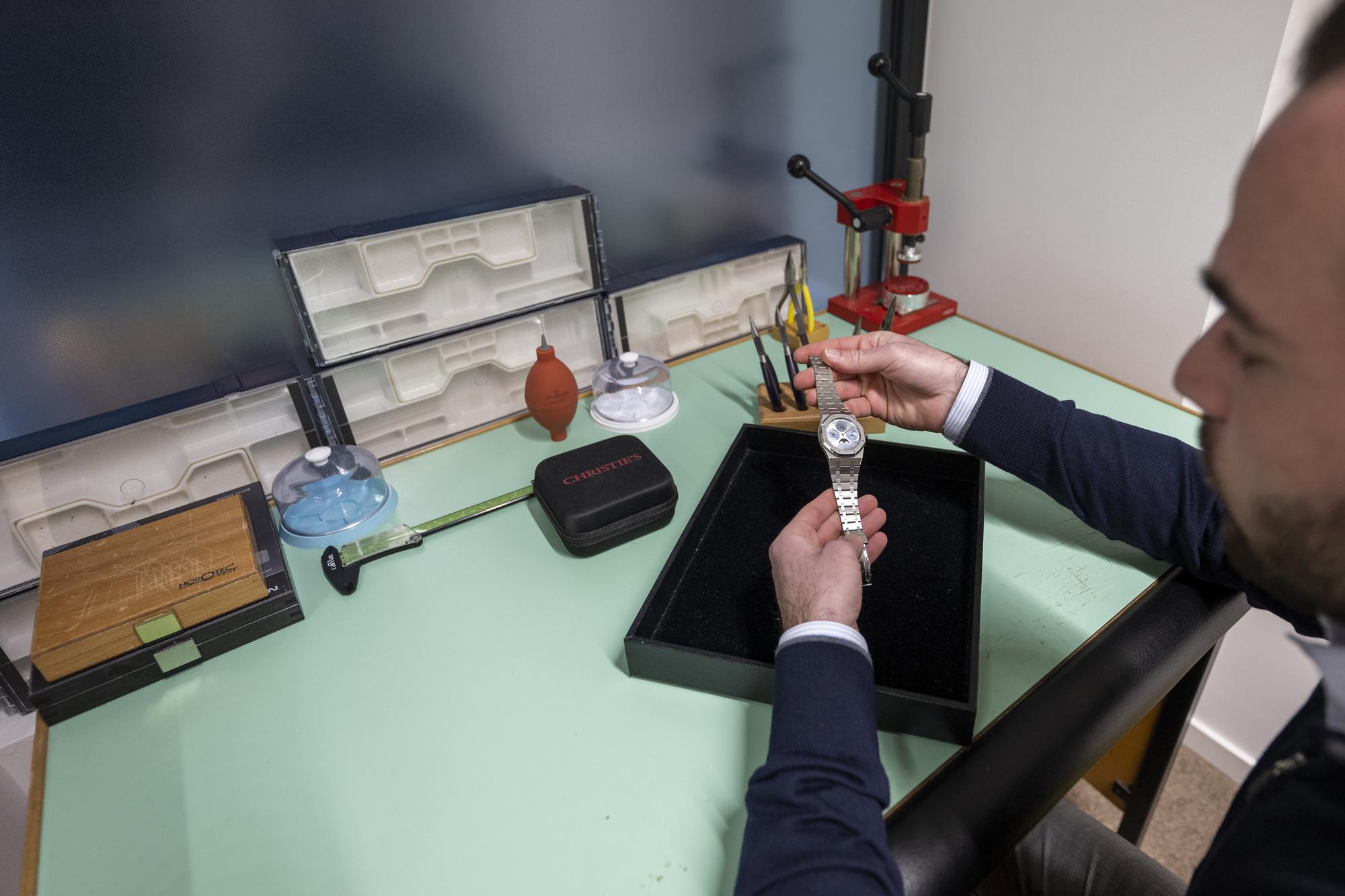 Un employe de chez Christie's regarde une montre dans les nouveaux bureaux de chez Christie's (International) SA Ventes aux encheres a Geneve, ce jeudi 19 janvier 2023. La multinationale s'est installee dans un immeuble a la rue du Mont-Blanc ou elle occupe 4 etages pour une equipe de trente-cinq personnes. (KEYSTONE/Martial Trezzini)