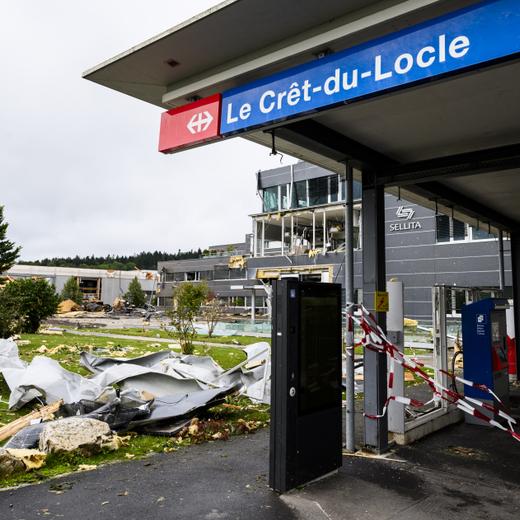 Des ouvriers enlevent les debris le long de la gare CFF, un jour apres le passage de la forte tempete le mardi 25 juillet 2023 au Cret-du-Locle a cote de La Chaux-de-Fonds. Le deblaiement des materiaux et la reparation des infrastructures ont repris mardi a La Chaux-de-Fonds dans le canton de Neuchatel, apres la violente tempête de la veille. (KEYSTONE/Jean-Christophe Bott)
