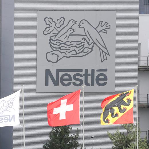 FILE PHOTO: A Swiss national flag flies beside a flag of the canton of Bern in front of the logo of Nestle at a plant in Konolfingen, Switzerland September 28, 2020. REUTERS/Arnd Wiegmann//File Photo