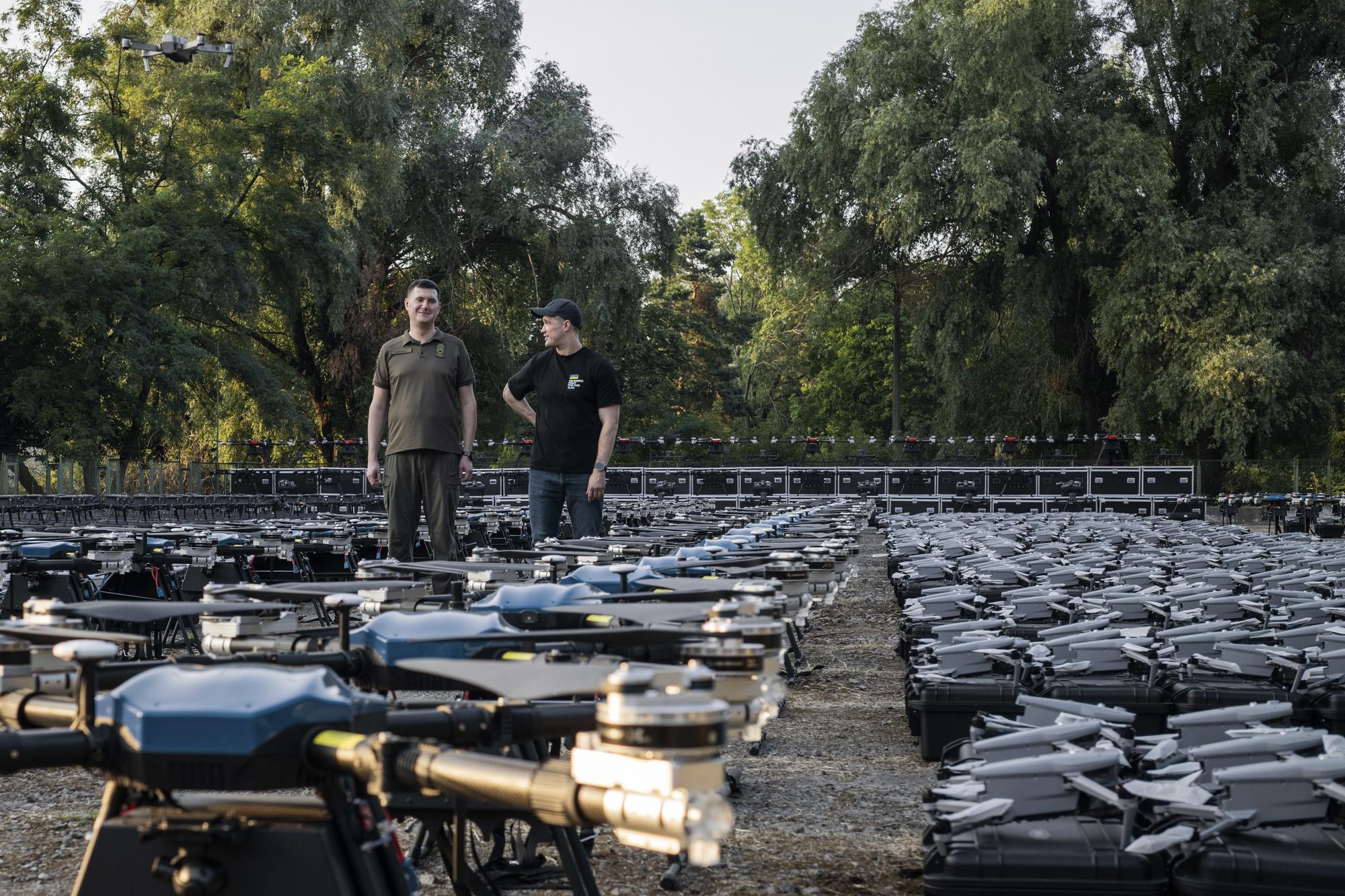 Mykhailo Fedorov, Ukrainian minister of digital transformation, right, and Yuriy Shchygol, head of State Special Communications Service, pose for a photo next to 1700 drones that are being sent to the frontline to be used against Russian forces, in Kyiv, Ukraine, Tuesday, July 25, 2023. (AP Photo/Libkos)