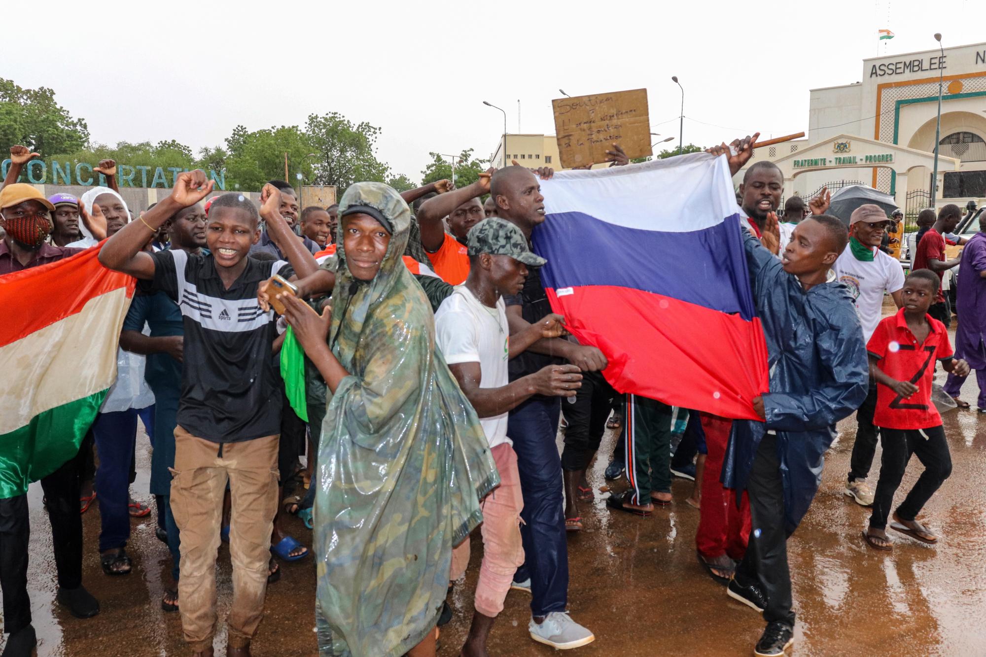 epa10771230 Supporters of putschist soldiers hold Niger's and Russia's flags as they celebrate outside the National Assembly building in Niamey, Niger, 27 July 2023. Mutinous soldiers calling themselves the National Council for the Safeguarding of the Country claimed to have overthrown President Mohamed Bazoum, Niger‚Äôs democratically elected President, in a Televised address on 26 July¬†evening. EPA/STR
