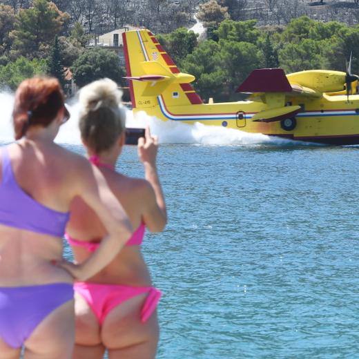 16.07.2023, Sibenik, CRO, Hitzewelle und Waldbrände in Kroatien, im Bild Touristen am Strand beobachteten des Wasser tanken des Löschflugzeugs während einer Waldbrandbekämpfung // Tourists on the beach watched the capabilities of the Air Tanker, which was extinguishing a local fire. Sibenik, Croatia on 2023/07/16. EXPA Pictures © 2023, PhotoCredit: EXPA/ Pixsell/ Hrvoje Jelavic *****ATTENTION - for AUT, SLO, SUI, SWE, ITA, FRA only***** - 20230717_PD4226 (KEYSTONE/APA/PIXSELL)
