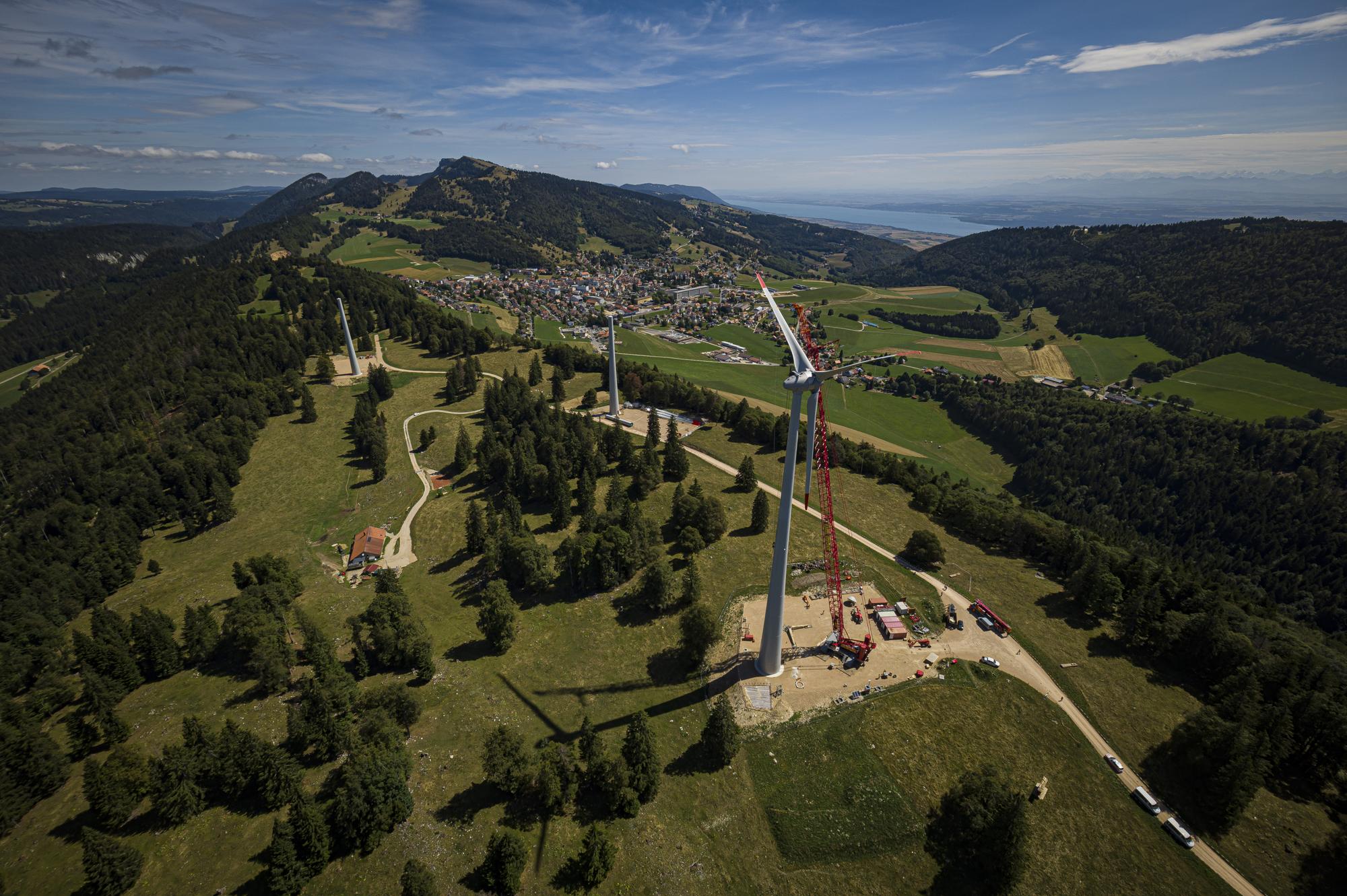 Une vue aerienne montre le montage de l'assemblage pales-rotor sur la premiere des six eoliennes du parc eolien de Sainte-Croix construit par Romande Energie ce lundi 31 juillet 2023 au dessus de Sainte-Croix. A terme les six eoliennes produiront 22 millions de kilowattheures par annee et permettront d'alimenter l'equivalent de la ville de Sainte-Croix. (KEYSTONE/Valentin Flauraud)