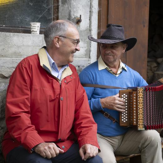 Le conseiller fédéral Guy Parmelin écoute un accordéoniste lors du brunch du 1er août à l'alpage de Seeweid, au Lac Noir.