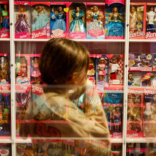 A girl looks at Barbie dolls as they are reflected on the glass in The Barbie Collector exhibition at The Wellington Museum, in Wellington, New Zealand July 31, 2023. REUTERS/Amanda Perobelli