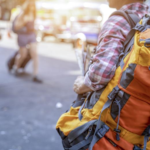 Young male backpacker walking in a famous street night market in Asia