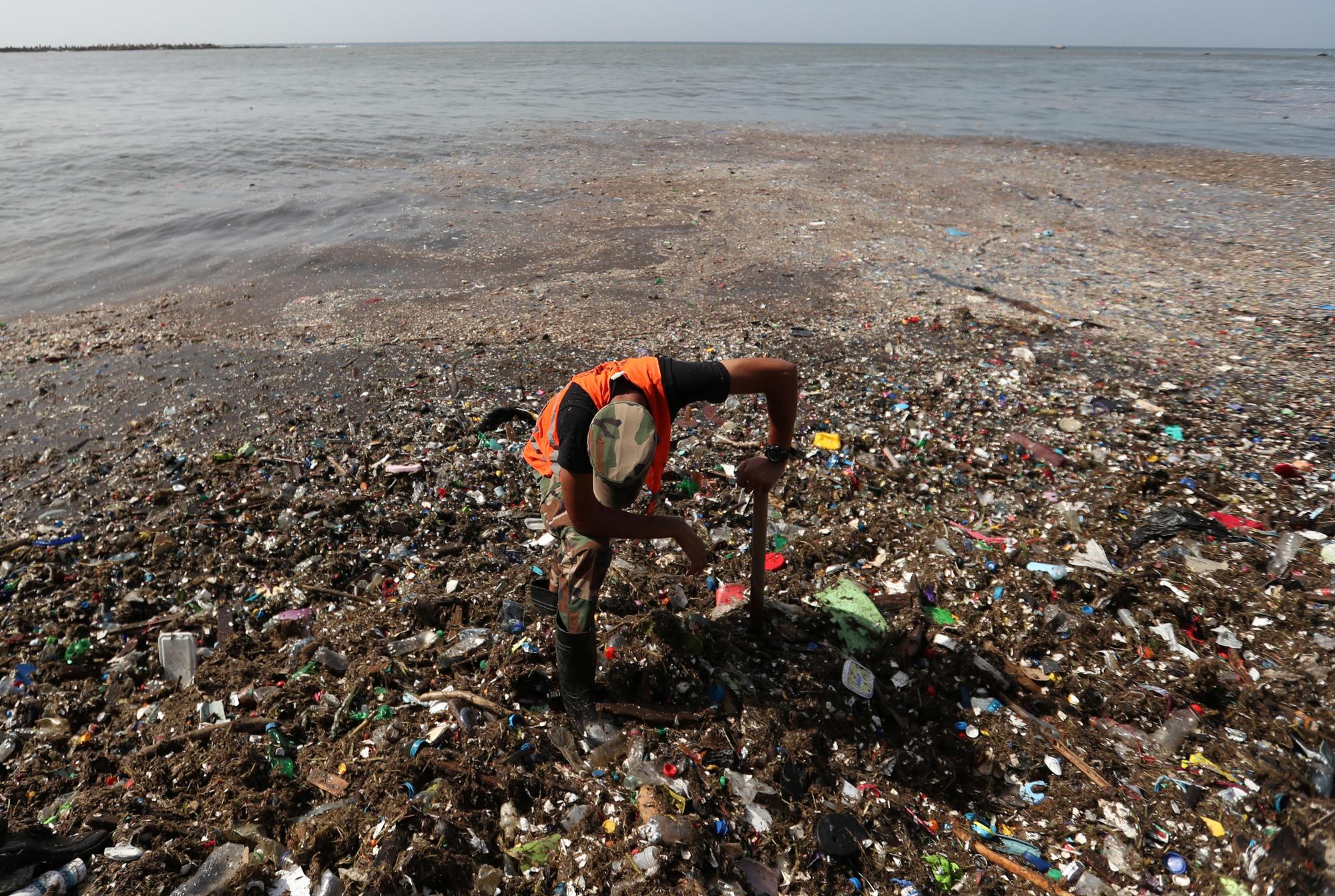 A soldier pauses while cleaning plastic and other debris on the shores of Montesinos beach, in Santo Domingo, Dominican Republic July 19, 2018. REUTERS/Ricardo Rojas