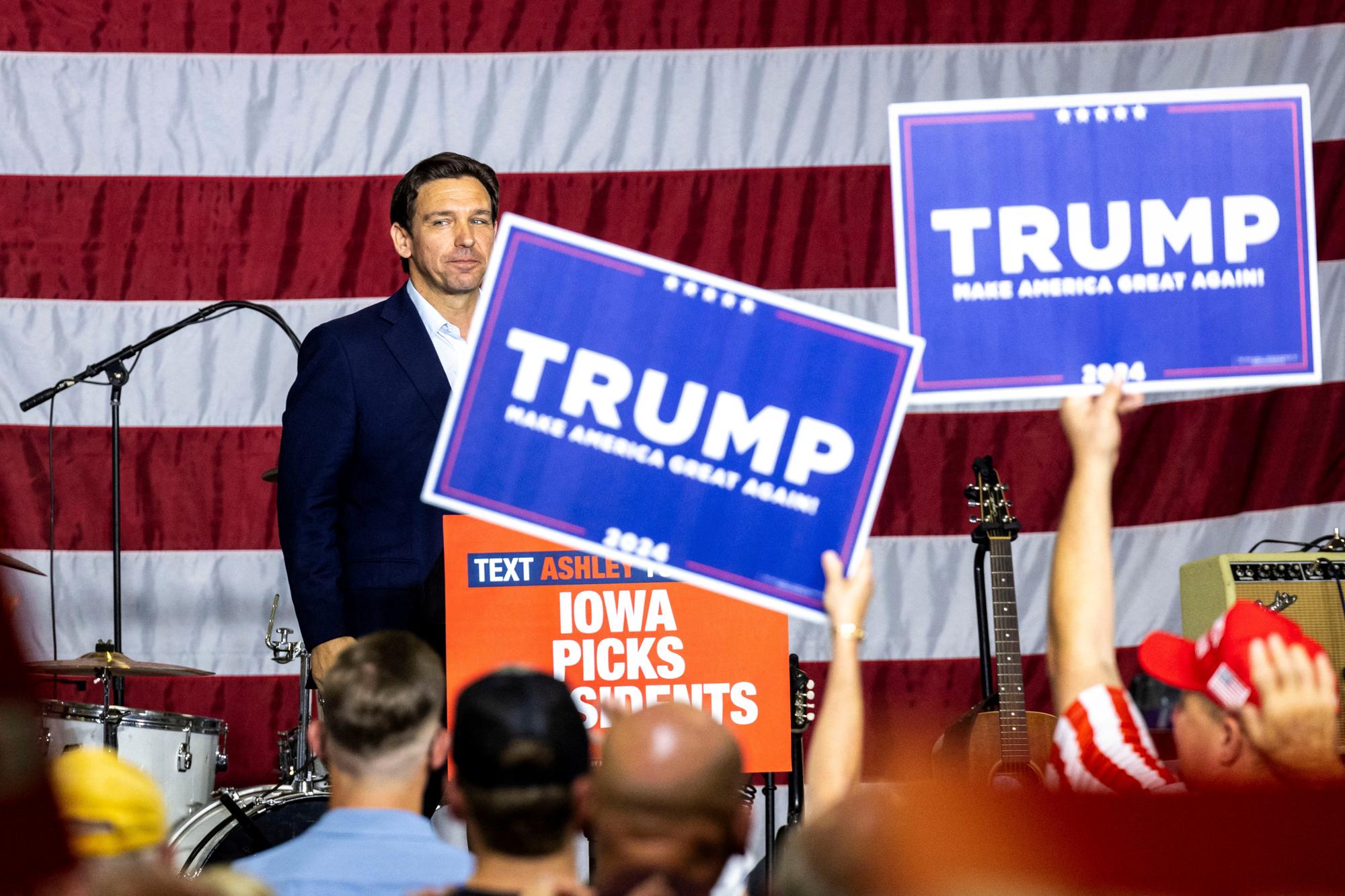 Republican U.S. presidential candidate and Florida Governor Ron DeSantis looks into the crowd after speaking as supporters of former President Donald Trump hold up signs during the Ashley's BBQ Bash fundraiser at Hawkeye Downs in Cedar Rapids, Iowa, U.S. August 6, 2023. Joseph Cress/USA Today Network via REUTERS. MANDATORY CREDIT. NO RESALES. NO ARCHIVES
