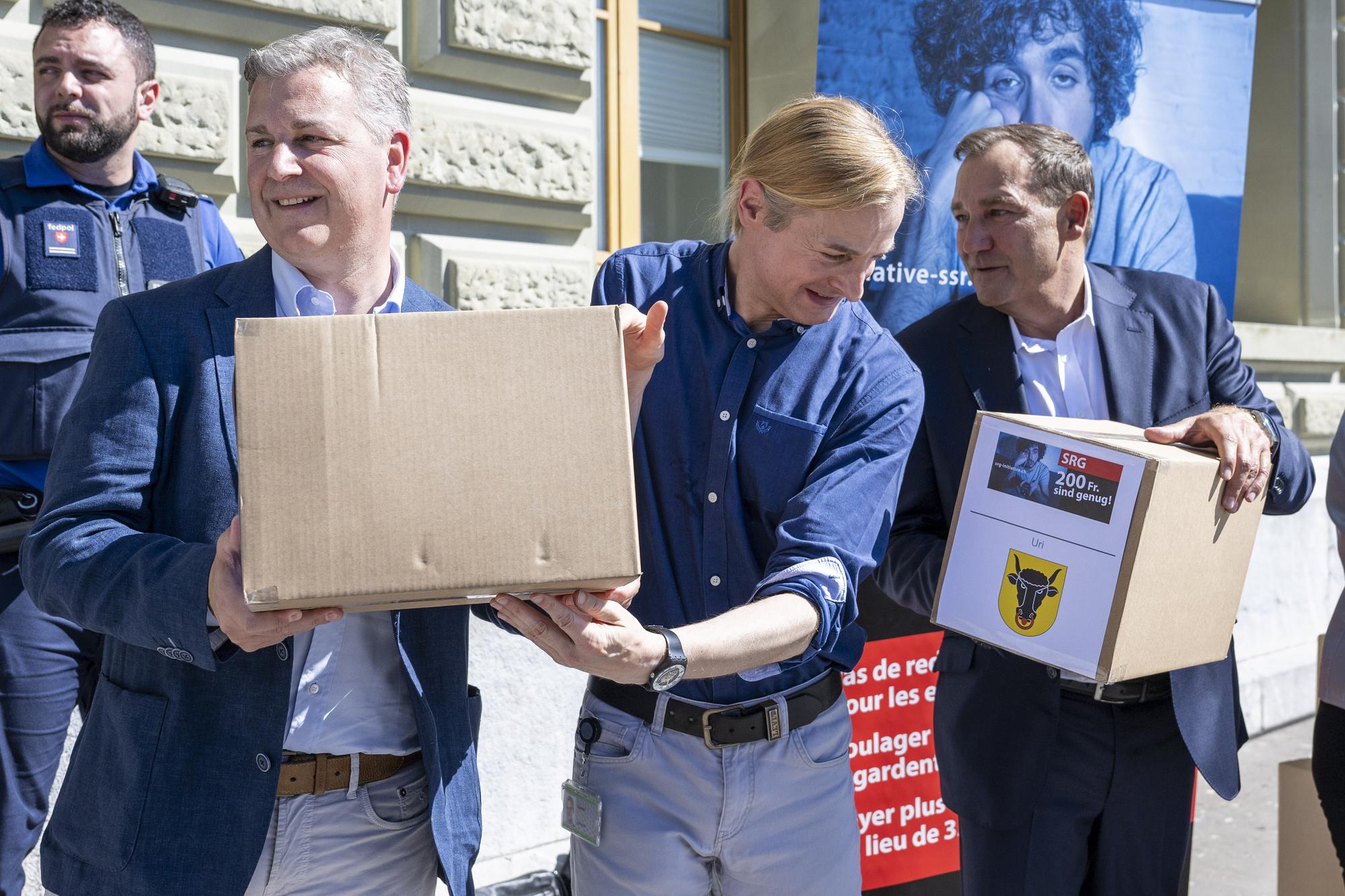 Staenderat Marco Chiesa, SVP-TI, Nationalrat Lorenzo Quadri, Lega-TI und Nationalrat Thomas Matter, von links, SVP-ZH, von links, reichen die SRG-Initiative "200 Franken sind genug" ein, am Donnerstag, 10. August 2023, in Bern. Die Initiative verlangt die Senkung der Serafe Gebuehren von jaehrlich 335 auf 200 Franken. (KEYSTONE/Peter Schneider)