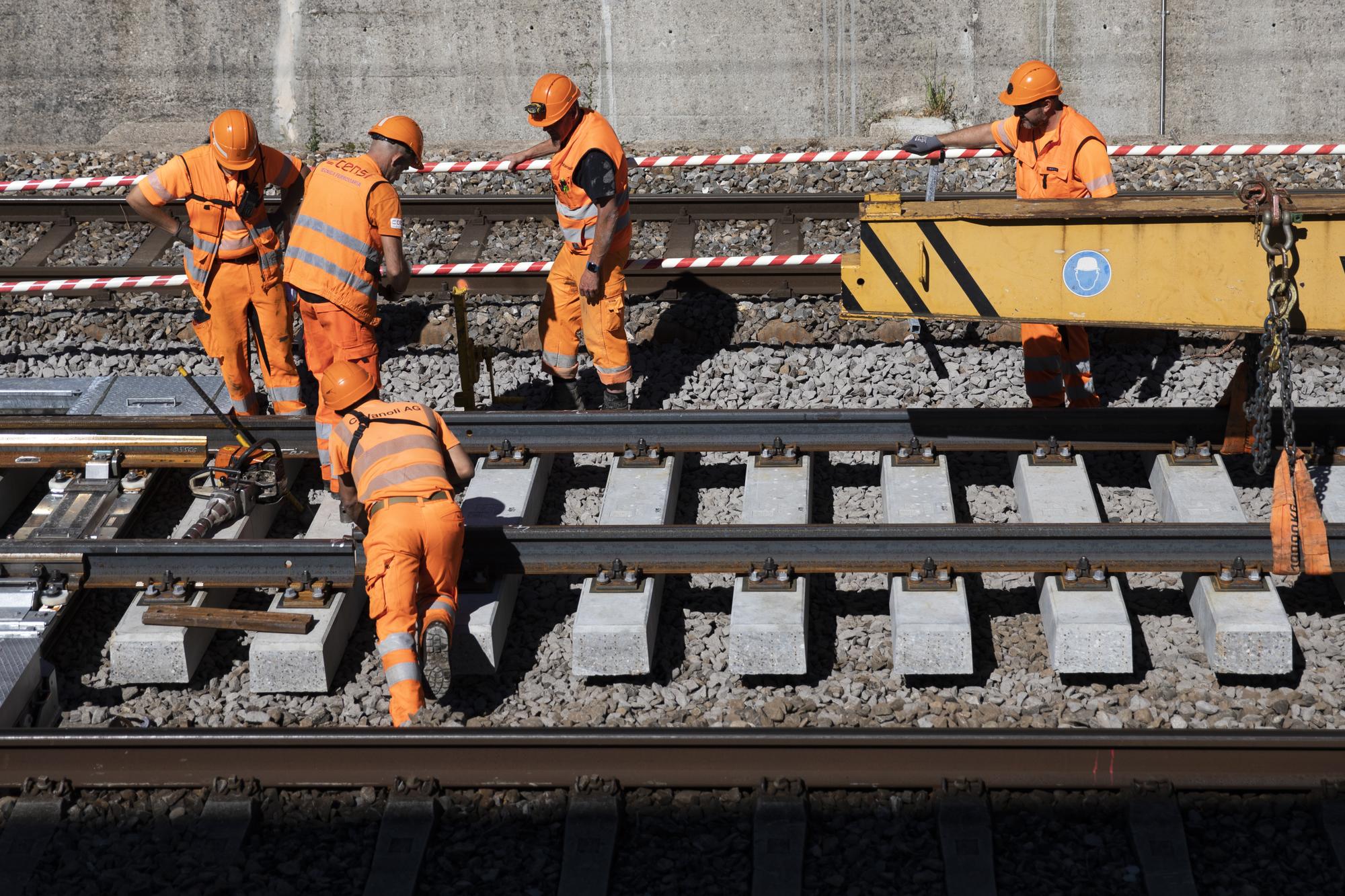 Gleisarbeiter verlegen ein Gleisstueck mit Betonschwellen, waehrend den Gleisarbeiten auf der Strecke zwischen Fribourg und Bern, am Montag, 27. Juli 2020 in Fribourg. Vom 5.7.2020 bis 14.8.2020 ist die Strecke zwischen Fribourg und Bern komplett gesperrt. Die SBB buendelt verschiedene Bauprojekte in dieser Zeit. (KEYSTONE/Peter Klaunzer)