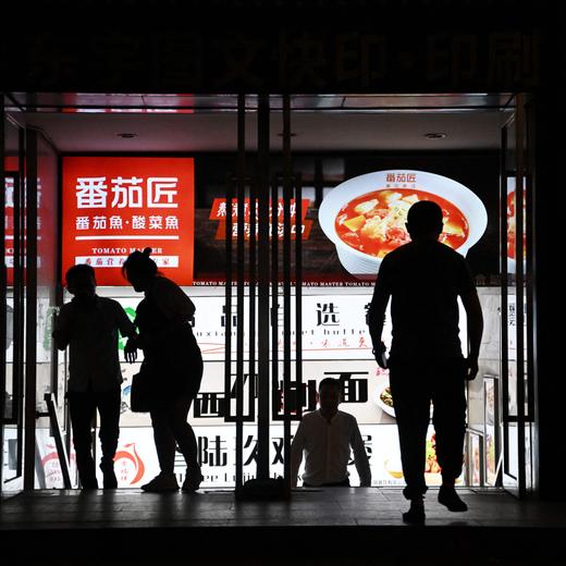 People leave a food court at a mall in Beijing on August 15, 2023. Global stocks fell on August 15, after disappointing data from China deepened concerns over the state of the world's second-largest economy. (Photo by Greg Baker / AFP)