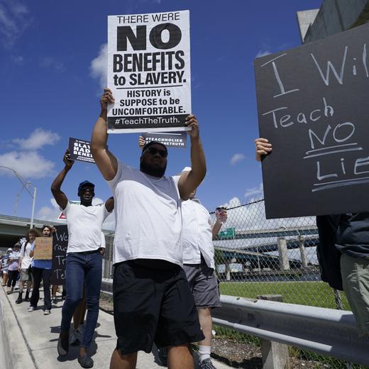 People carry signs during the "Teach No Lies" march to the School Board of Miami-Dade County to protest Florida's new standards for teaching Black history, which have come under intense criticism for what they say about slavery, Wednesday, Aug. 16, 2023, in Miami. (AP Photo/Lynne Sladky)