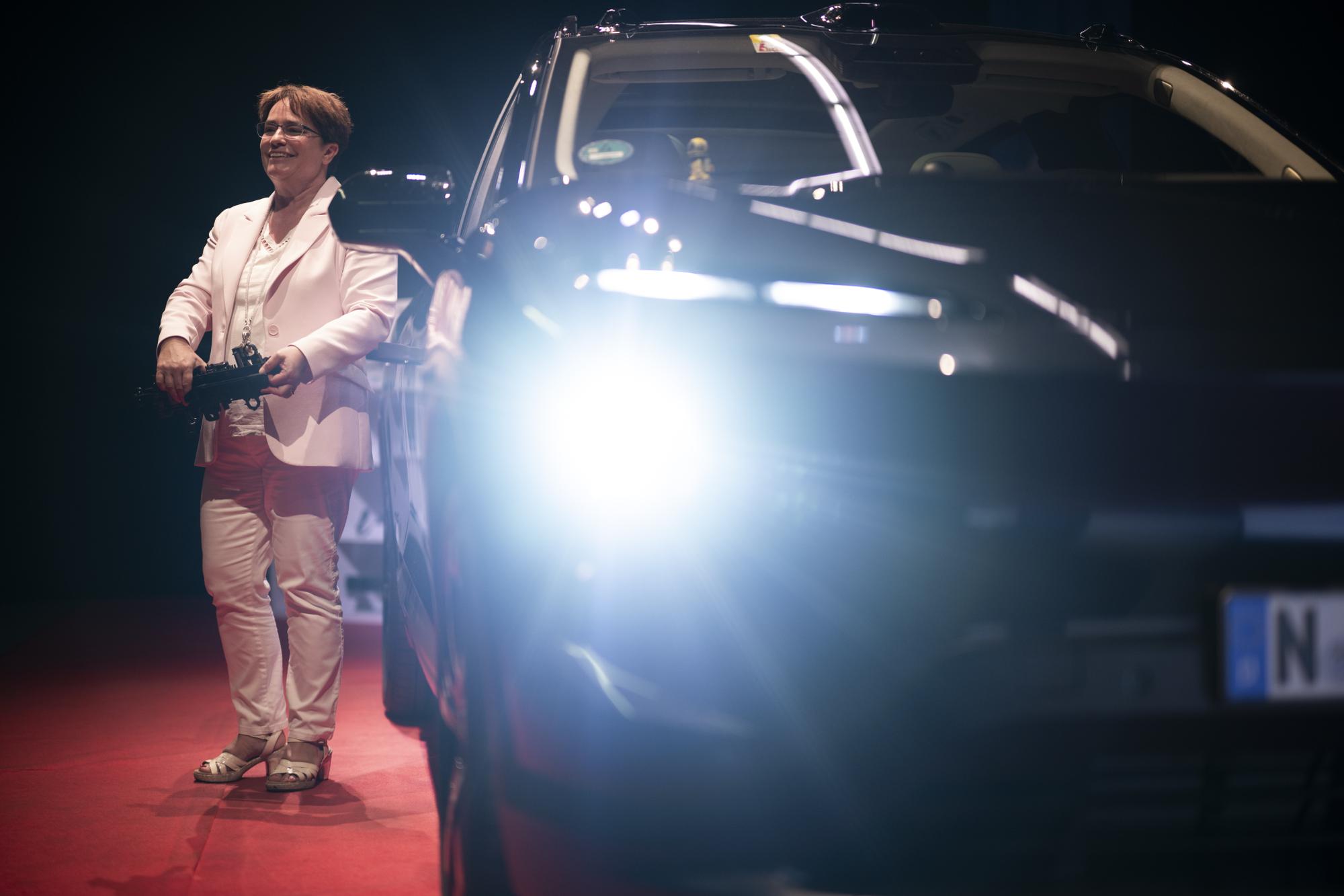 CEO Magdalena Martulla-Blocher posiert mit einem Tuergriff vor einem Nio Elektroauto, zu dem die Ems Chemie Teile herstellt, nach der Bilanzmedienkonferenz zum Halbjahresabschluss der Ems Chemie, am Freitag, 14. Juli 2023, in Domat/Ems. (KEYSTONE/Gian Ehrenzeller)