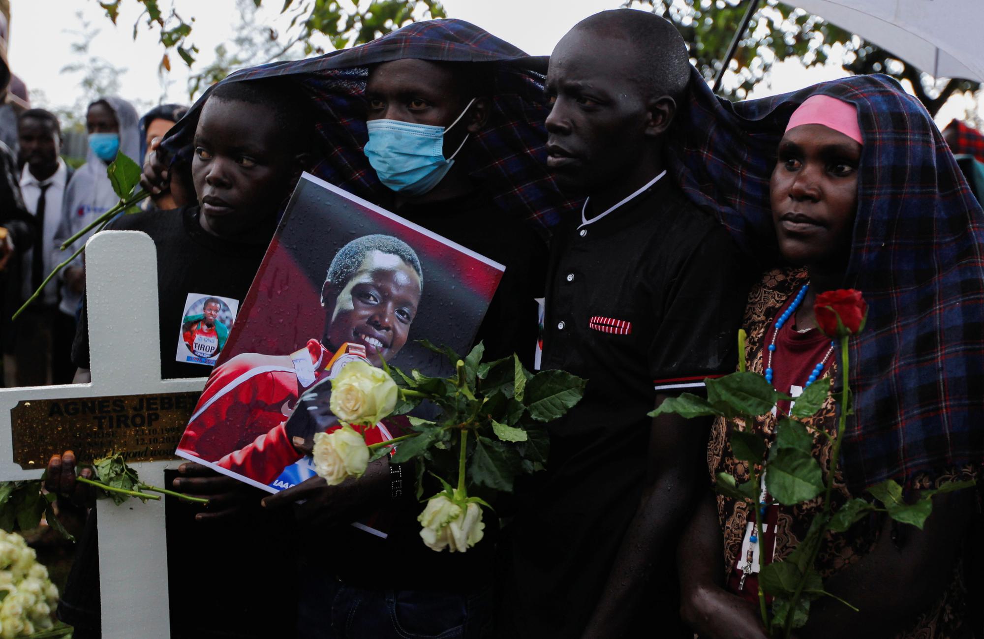 Family members hold roses as they attend the burial of long-distance runner Agnes Tirop at Kapnyamisa village, Nandi county, Kenya, October 23, 2021. REUTERS/Monicah Mwangi