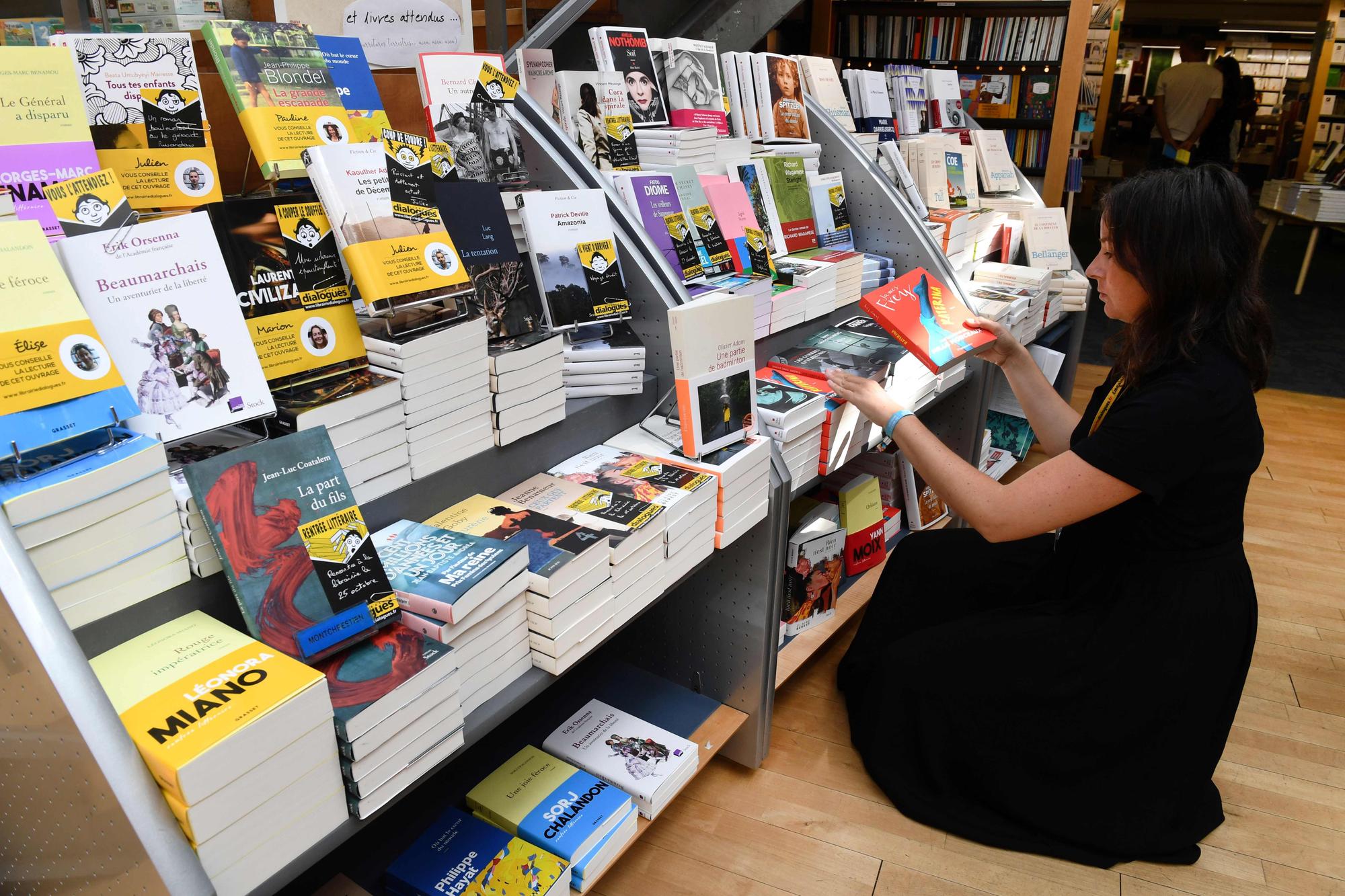 A bookseller displays books for the 'rentree litteraire' (the start of a publishing season) on the stalls of a bookshop in Brest, western France, on August 23, 2019. - The first titles of the autumn season have begun to appear and a total of 524 novels including 336 French and 188 foreigner are expected in bookstores by the end of October. (Photo by Fred TANNEAU / AFP)