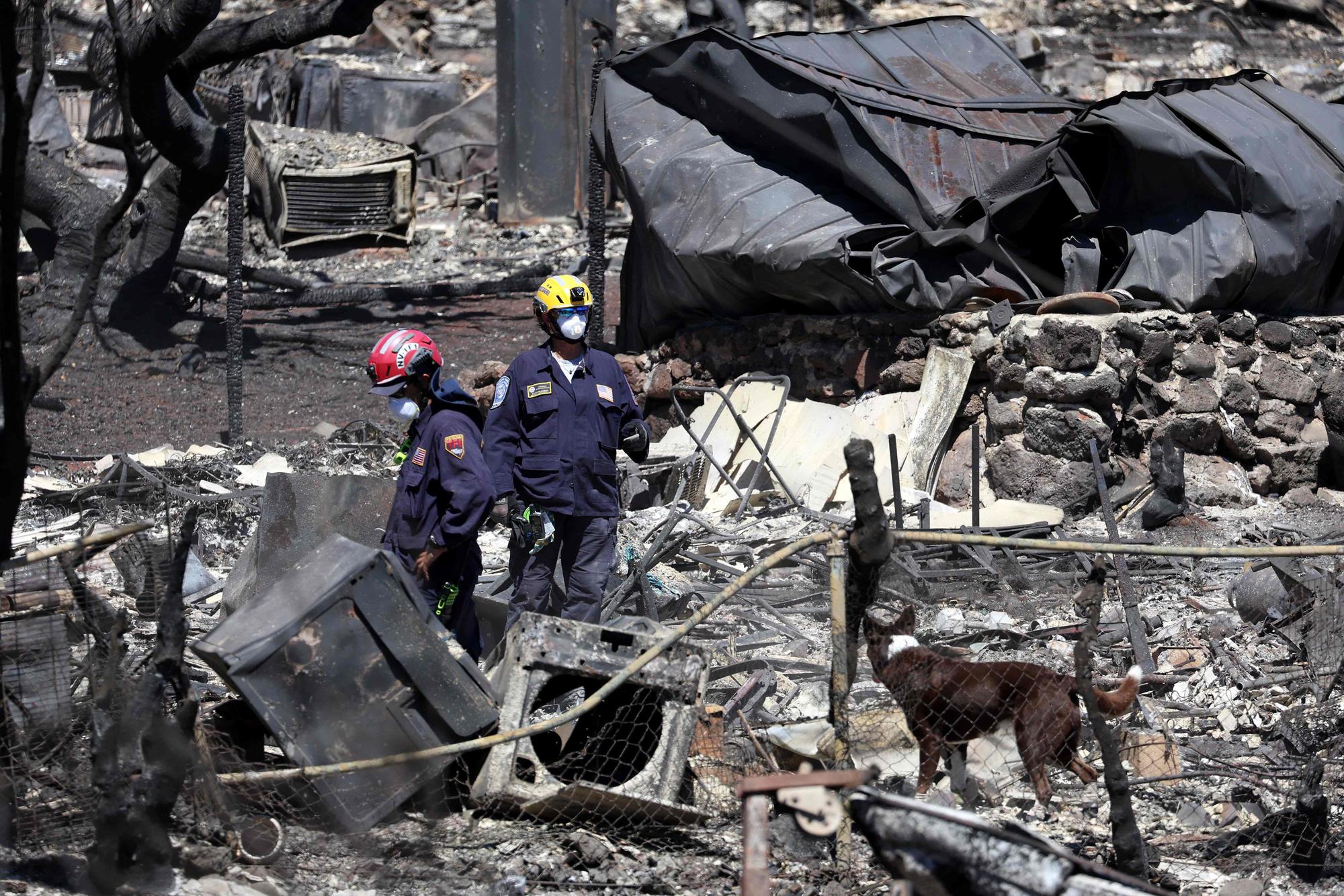 Des équipes de recherche et de sauvetage examinent les vestiges d'un quartier le 17 août 2023 à Lahaina, Hawaï.