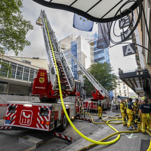Des pompiers du SIS (Services Incendie et Secours) interviennent sur un incendie de la toiture du cinema le Plaza, ce samedi 19 aout 2023 Geneve. (KEYSTONE/Martial Trezzini)