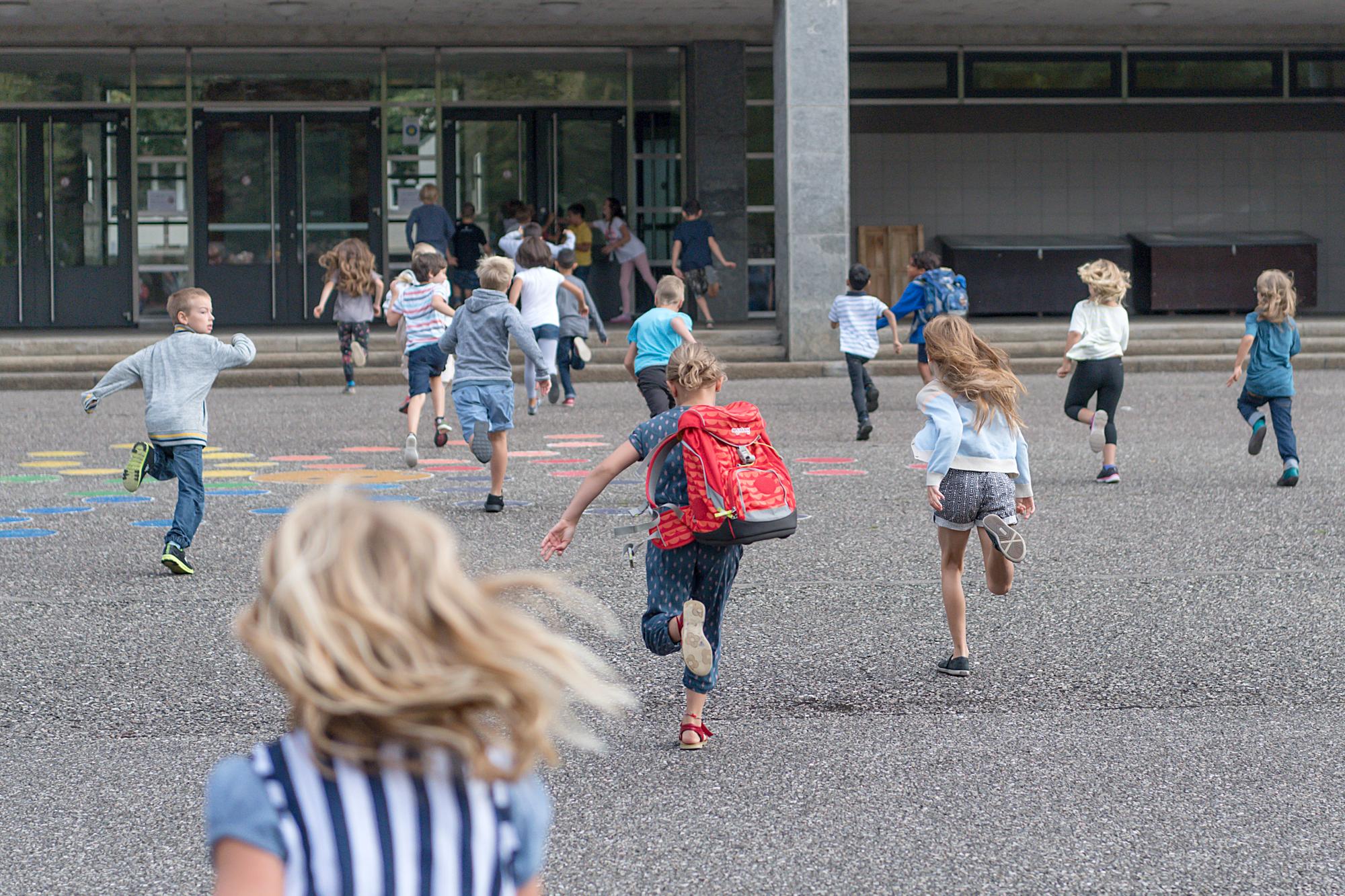 Kinder rennen in's Schulhaus am ersten Schultag im Kanton Basel-Stadt auf dem Pausenplatz vor dem Schulhaus Gottfried Keller in Basel am Montag, 14. August 2017. (KEYSTONE/Georgios Kefalas)
