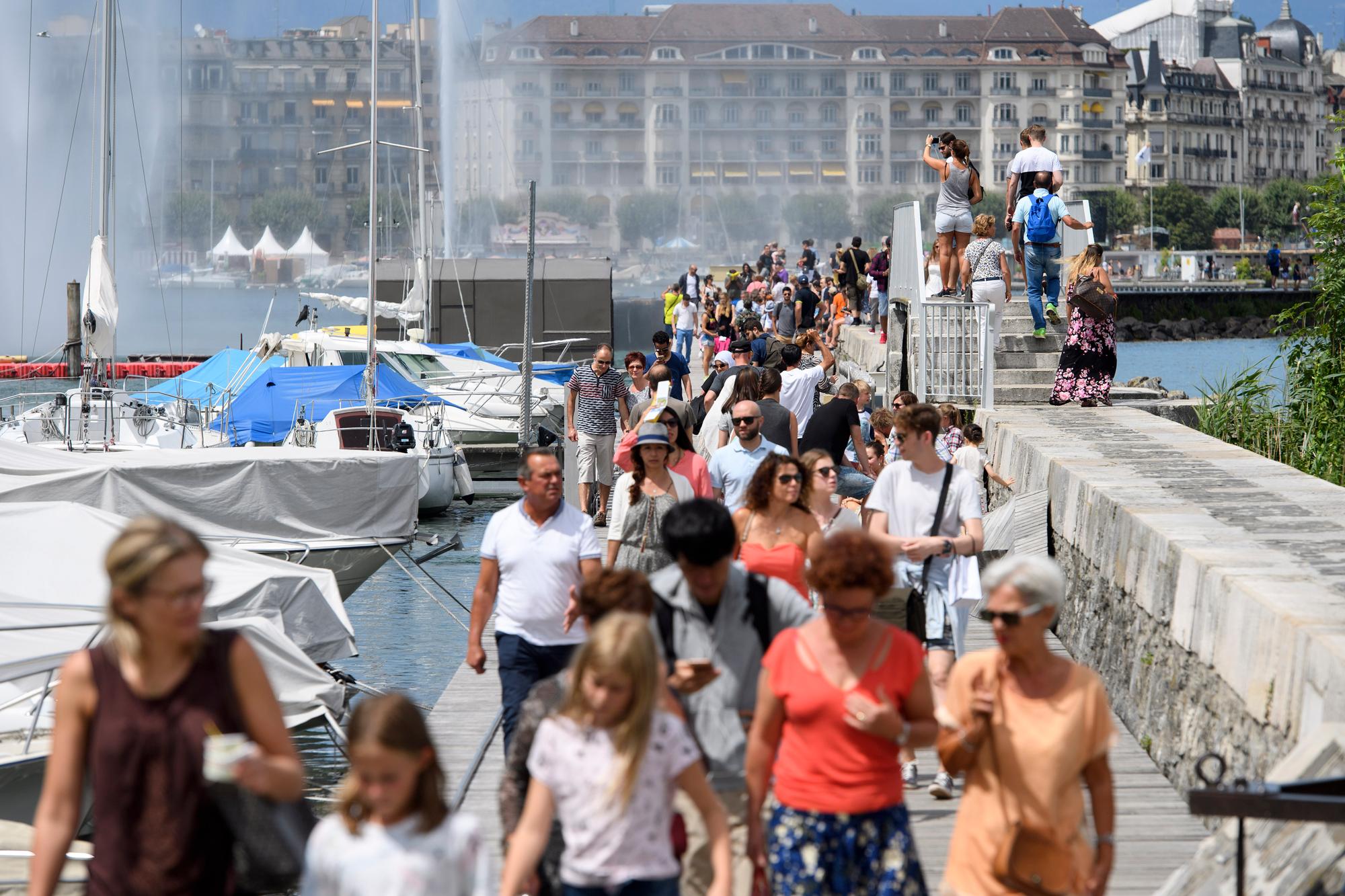Des touristes se baladent sur la jetee du jet d'eau, ce samedi 29 juillet 2017 a Geneve. (KEYSTONE/Martial Trezzini)