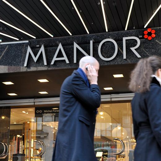 Des personnes photographie devant l'entree du magasin Manor, ce jeudi 28 octobre 2010 a Geneve. (KEYSTONE/Martial Trezzini)