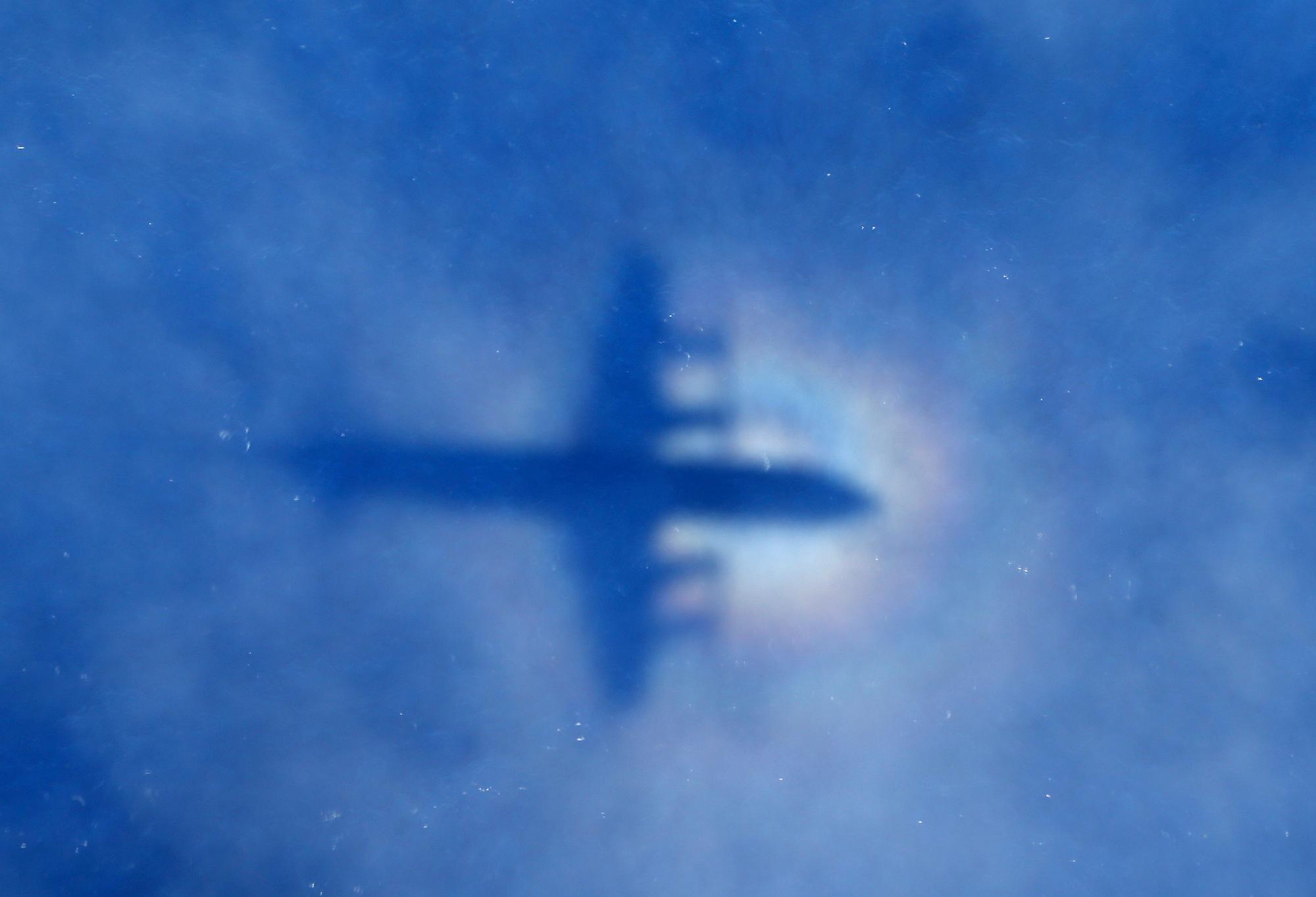 In this Monday, March 31, 2014 photo, a shadow of a Royal New Zealand Air Force P-3 Orion aircraft is seen on low cloud cover while it searches for missing Malaysia Airlines Flight MH370 in the southern Indian Ocean. Malaysia's national police chief has warned that the investigation into what happened to the plane may take a long time and may never determine the cause of the tragedy. Khalid Abu Bakar said Wednesday, April 2, that the criminal investigation is still focused on four areas — hijacking, sabotage and personal or psychologica problems of those on board the plane. (AP Photo/Rob Griffith, Pool)