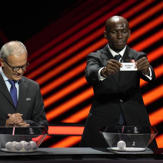 Stephane Mbia, from Cameroon, standing with Italian football manager Claudio Ranieri, shows the ticket with the name of AS Roma during the 2023/24 UEFA Europa League group stage draw at the Grimaldi Forum in Monaco, Friday, Sept. 1, 2023. (AP Photo/Daniel Cole)
