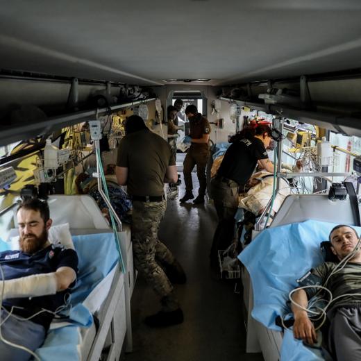 epa10646693 Paramedics from the international volunteer team of Hospitallers battalion give medical aid to injured serviceman to a medical bus at an undisclosed location, Donetsk region, 22 May 2023. "Hospitallers" is a volunteer organization of paramedics, founded in 2014. One of the directions of their work is to evacuate injured people from the areas close to the frontline to big hospitals by a special medical bus, named after their fallen comrade "Avsriyka" (Austrian). In the last three months they have evacuated more than 900 people. Russian troops entered Ukraine on 24 February 2022 starting a conflict that has provoked destruction and a humanitarian crisis. EPA/OLEG PETRASYUK