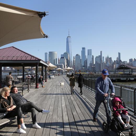 People enjoy the waterfront that overlooks the skyline of lower Manhattan in Jersey City, N.J., Wednesday, Nov. 6, 2019. Voters in the New Jersey city approved restrictions on Airbnb and other short-term rental companies on Tuesday, Nov. 5. (AP Photo/Seth Wenig)