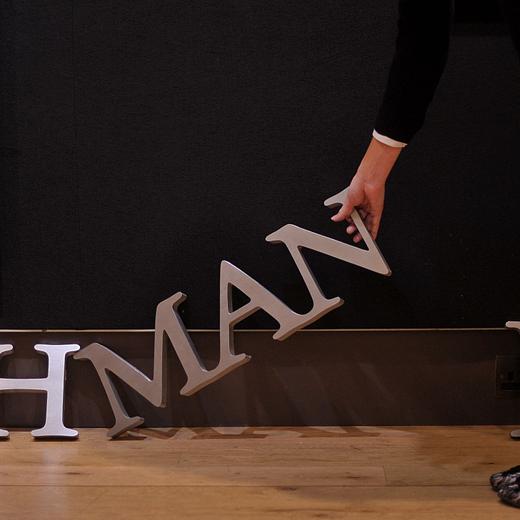 (FILES) An employee poses for photographers with part of a Lehman Brothers company sign at Christie's auction house in London on September 24, 2010. The sign will be sold as part of the 'Lehman Brothers: Artwork and Ephemera' sale in London on September 29. AFP PHOTO / BEN STANSALL (Photo by Ben STANSALL / AFP)
