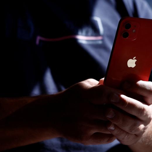 A man poses with an Apple iPhone 12 in a mobile phone store in Nantes, France, September 13, 2023. REUTERS/Stephane Mahe
