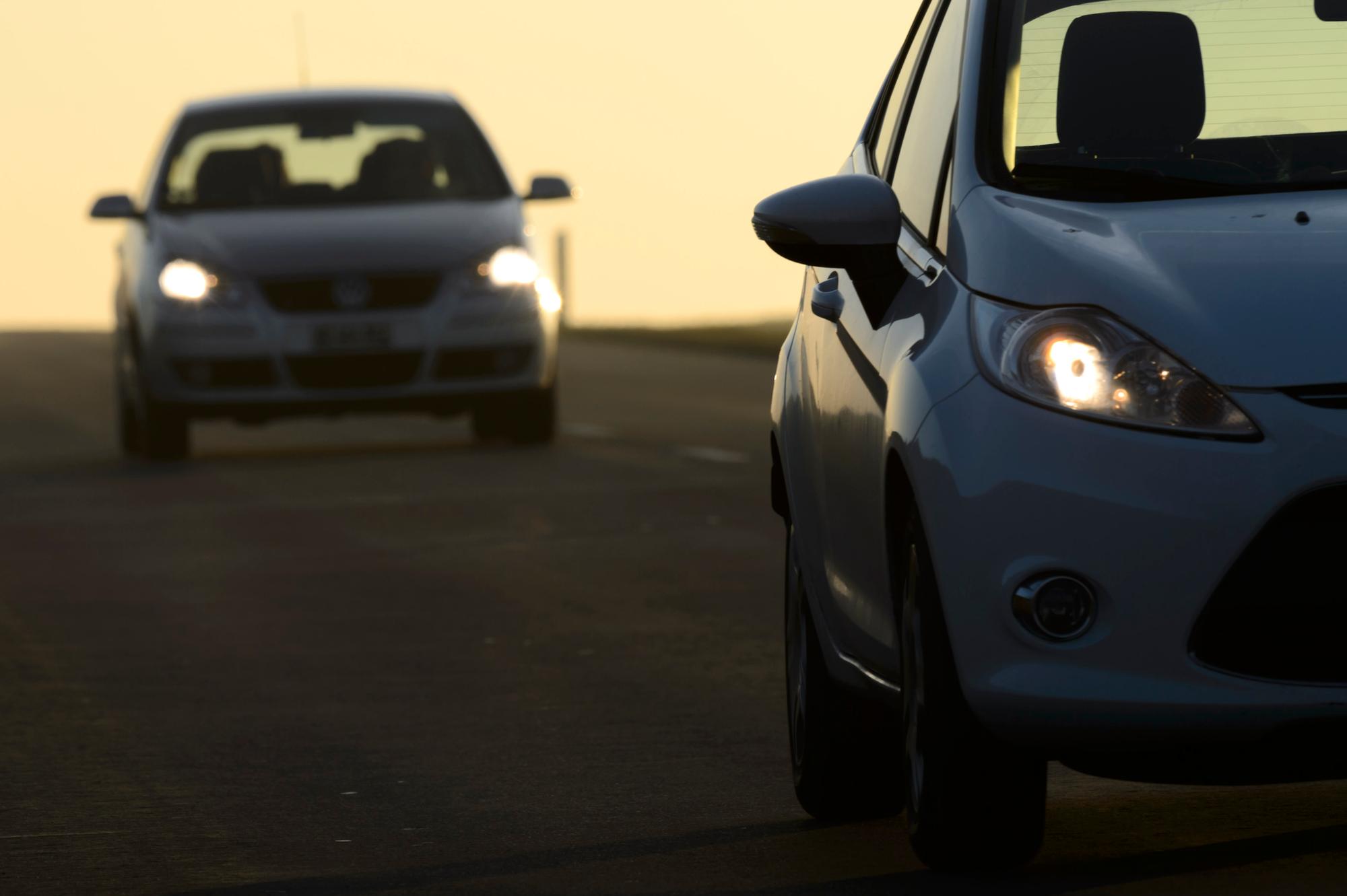 Une voiture roule en plein jour avec ses phares allumes sur une route cantonale vaudoise ce mercredi 4 decembre 2013 a Daillens, Vaud. Une modification de la loi sur la circulation routiere qui entrera en vigueur des le 1er janvier 2014 dans le cadre du programme federal Via Sicura: tous les automobilistes roulant en Suisse, que ce soit sur une voiture, un camion ou un deux-roues, devront rouler de jour avec les feux de croisement allumes. (KEYSTONE/Laurent Gillieron)