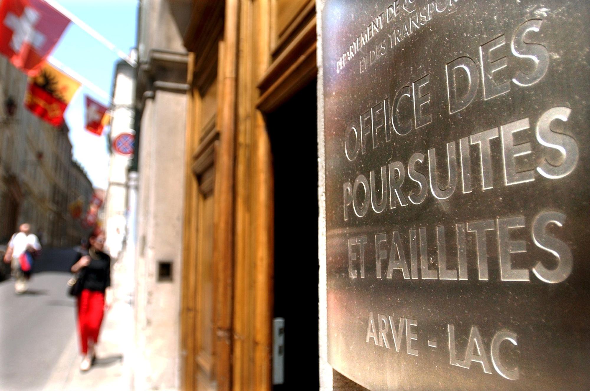 Une personne passe devant l'entree du batiment de l' office des poursuites et faillites Arve - Lac ce lundi 17 juin 2002 dans la vieille ville de Geneve. Le conseil d' Etat genevois sanctionne sept employes dans le cadre de l'affaire des offices des poursuites et faillites, OPF, du canton de Geneve. (KEYSTONE/Laurent Gillieron)