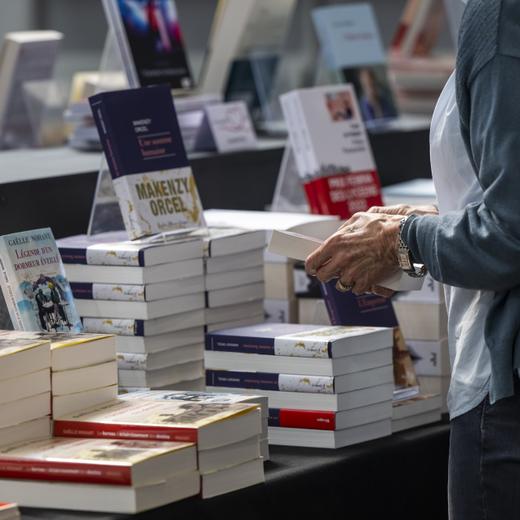 Une visiteuse regarde des livres, lors de l'ouverture du Salon du livre, ce mercredi, 22 mars 2023, a Geneve. La 33eme edition du Salon du Livre se deroulera du 22 mars au 26 mars a Palexpo Geneve. (KEYSTONE/Martial Trezzini)