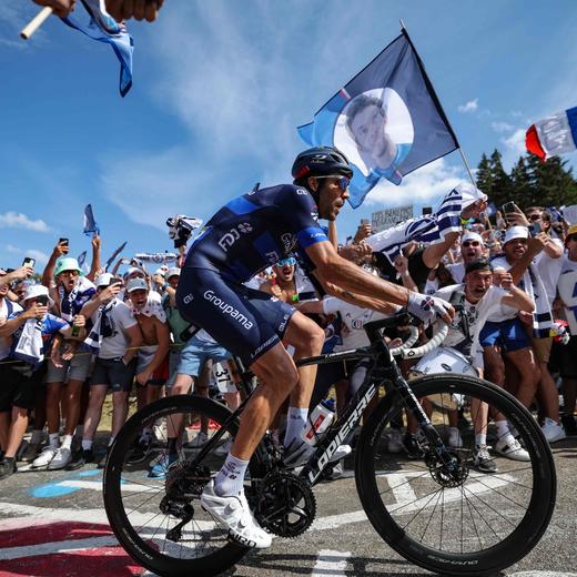 (FILES) Groupama - FDJ's French rider Thibaut Pinot cycles past fans in "Pinot corner" in the ascent of the Petit Ballon in the final kilometres of the 20th stage of the 110th edition of the Tour de France cycling race 133 km between Belfort and Le Markstein Fellering, in Eastern France, on July 22, 2023. Thibaut Pinot, the idol of French cycling, is putting in his final pedal strokes this week in Italy before hanging up his bike for good and leaving behind the legacy of a rider like no other. (Photo by Thomas SAMSON / AFP)