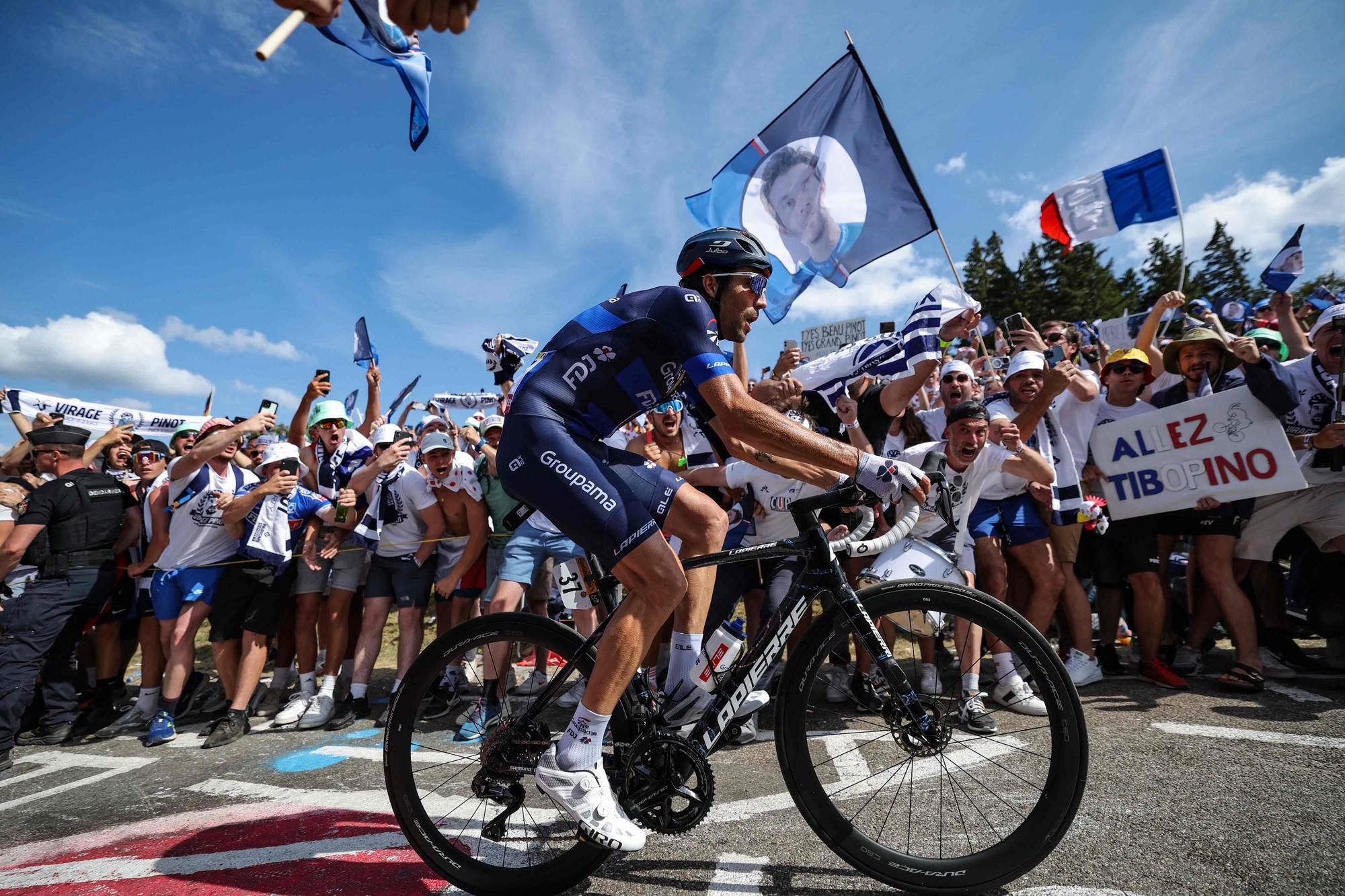 (FILES) Groupama - FDJ's French rider Thibaut Pinot cycles past fans in "Pinot corner" in the ascent of the Petit Ballon in the final kilometres of the 20th stage of the 110th edition of the Tour de France cycling race 133 km between Belfort and Le Markstein Fellering, in Eastern France, on July 22, 2023. Thibaut Pinot, the idol of French cycling, is putting in his final pedal strokes this week in Italy before hanging up his bike for good and leaving behind the legacy of a rider like no other. (Photo by Thomas SAMSON / AFP)