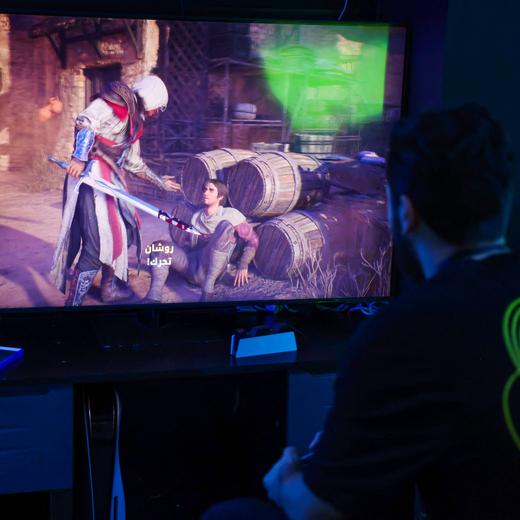 A man plays the newly released video game 'Assassin's Creed Mirage' in a cybercafe in Baghdad on October 4, 2023. After years of turbulence that saw several top executives out the door, Ubisoft is betting aggressively on 'Assassin's Creed Mirage,' set in ninth-century Baghdad during the Abbasid caliphate era, to level up profits for the French publisher with a steadier line-up of new releases. (Photo by Ahmad AL-RUBAYE / AFP)