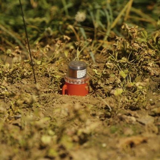 Un géophone posé dans le sol.