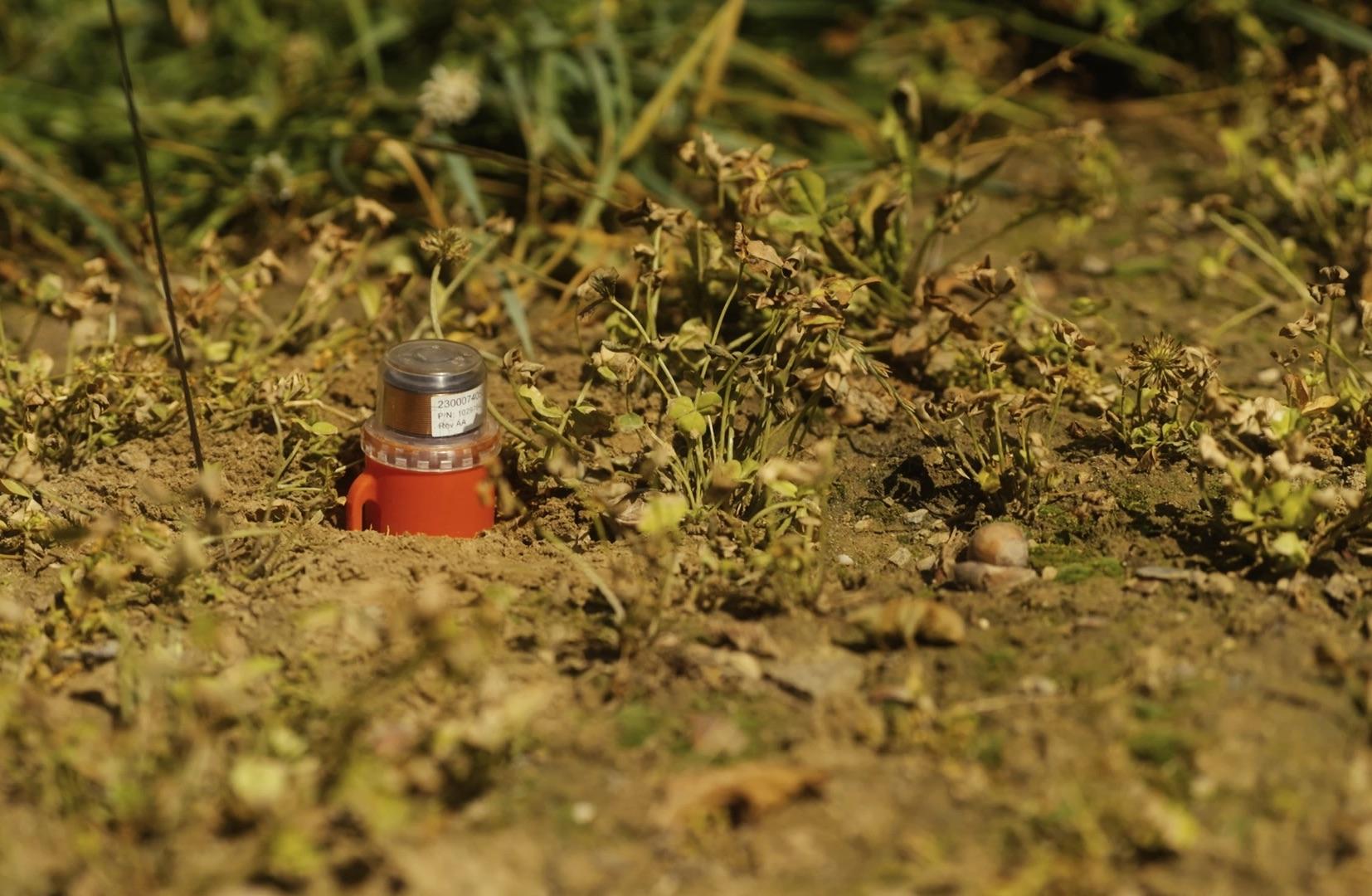 Un géophone posé dans le sol.