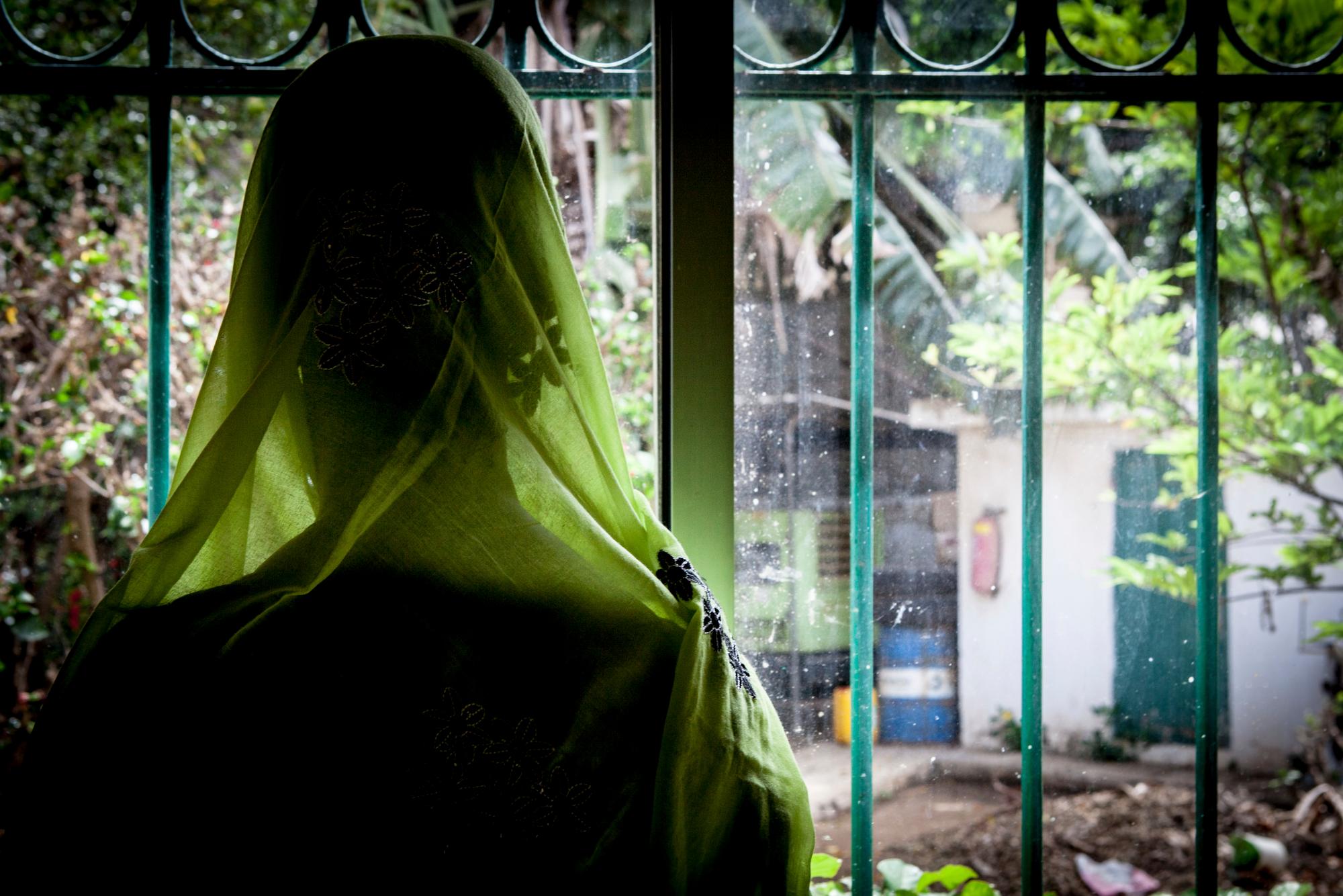 Diakite, 46, looks out the window after her annual check up with Dr. Abdoul Aziz Kasse at the Clinique des Mamelles in Dakar, Senegal on Thursday, July 13, 2017. Diakite has successfully recovered from cervical cancer thanks to Dr. Kasse and annually checks. The word cancer is rarely spoken in Senegal, synonymous with death in a country where many are only diagnosed in the later stages of disease and radiation therapy can be difficult to access. Cancer has become an emerging public health problem in West Africa, and the lack of strong prevention, good screening and treatment often leaves outcomes grim. (AP Photo/Jane Hahn)