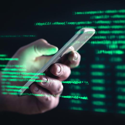 Darkweb, darknet and hacking concept. Hacker with cellphone. Man using dark web with smartphone. Mobile phone fraud, online scam and cyber security threat. Scammer using stolen cell. AR data code.