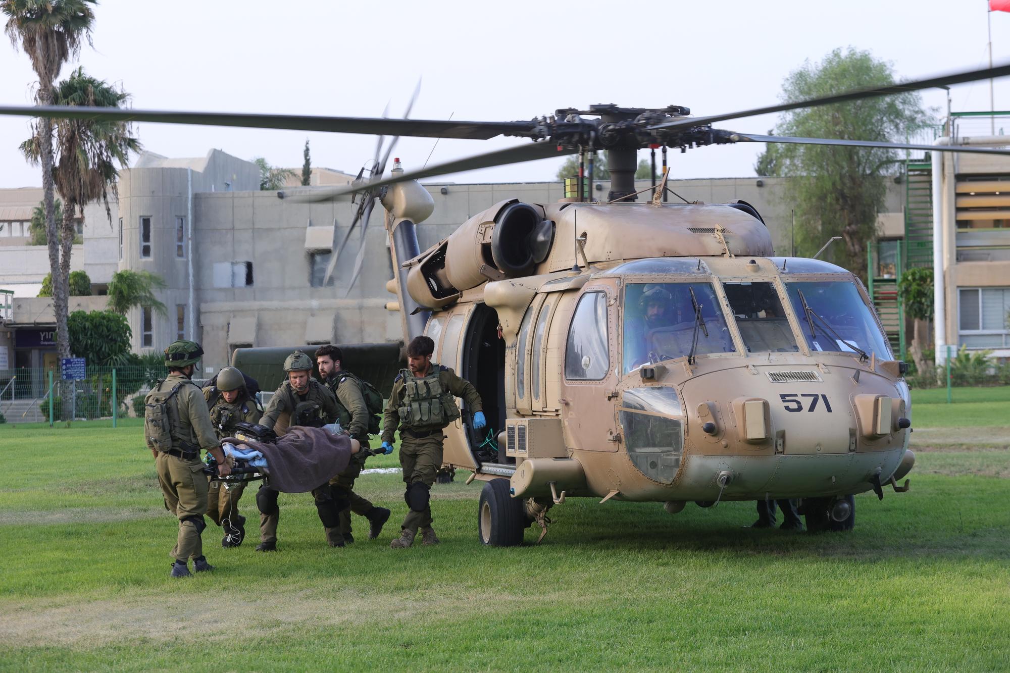 epa10907599 Israeli soldiers load a stretcher with a victim from a helicopter as they arrive at the grounds of the Soroka Medical Center in the southern city of Beersheba, Israel, 08 October 2023. Numerous wounded Israeli soldiers and civilians who were evacuated from the Hamas rocket attack sites were airlifted to the hospital by airlifts of the Israeli military and the Magen David Adom Israeli emergency service. Surprise attacks on Israel on 07 October claimed by the Islamist movement Hamas killed more than 670 Israelis and left over 2,100 injured in the attacks, the Israeli army said 08 October. EPA/ABIR SULTAN