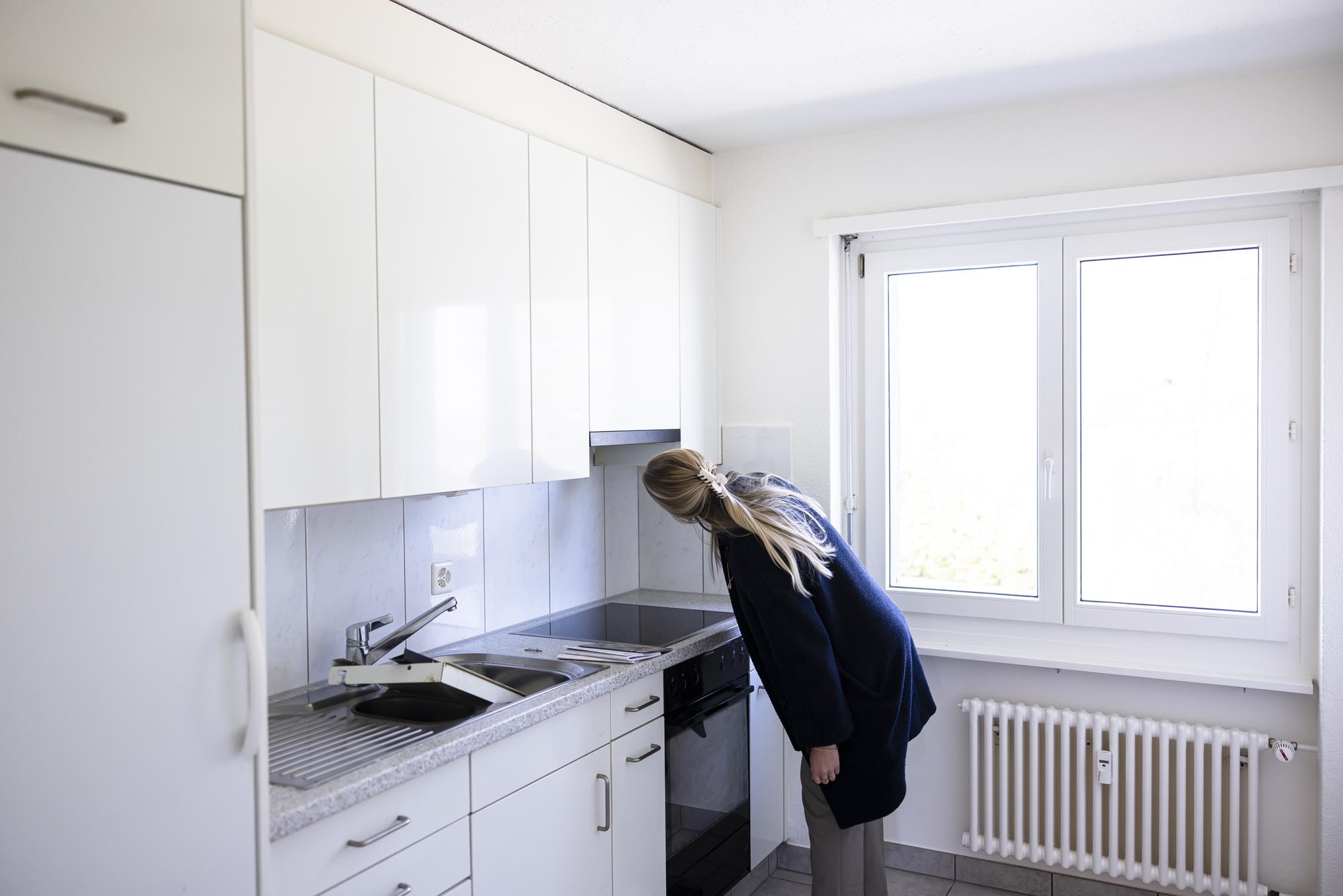 Eine Interessentin betrachtet die Kueche waehrend einer Wohnungsbesichtigung in einer Wohnung der Liegenschaften Stadt Zuerich (LSZ) am Dienstag, 28. Maerz 2023 in Zuerich. (KEYSTONE/Michael Buholzer)