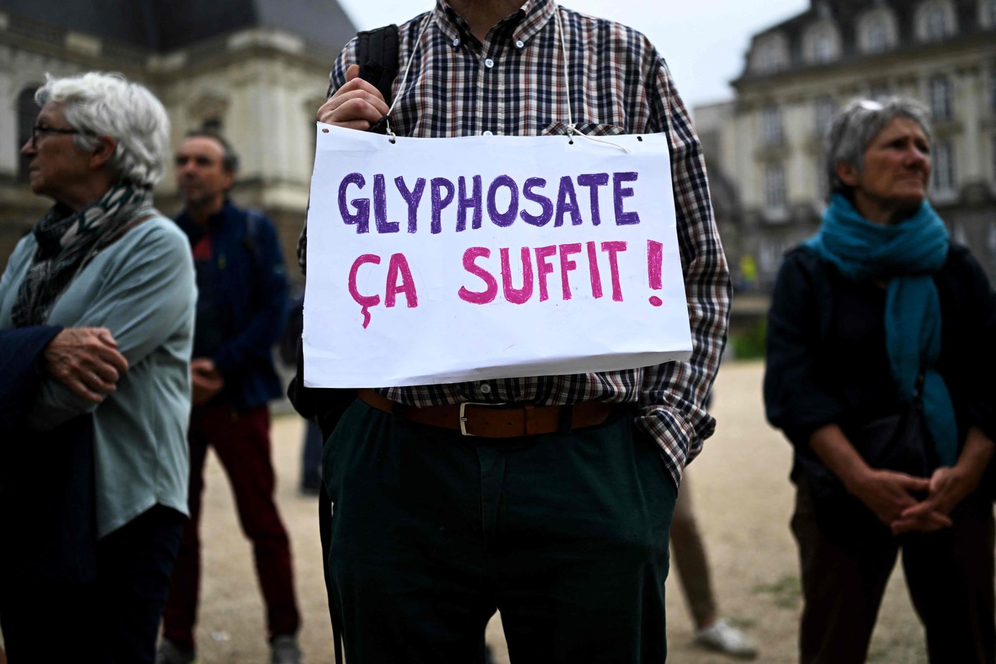A man holds a placard reading in French "Glyphosate, it's enough!" as he takes part in a gathering next to "the Maison de l'Europe" in Rennes, western France, to protest against glyphosate-based herbicide authorization which European Union member states are debating a ten-year extension, on october 12, 2023. (Photo by Damien MEYER / AFP)