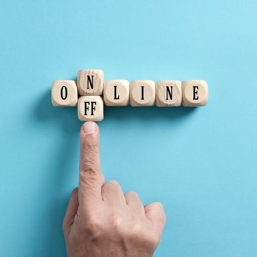 Going offline. To choose between online and offline. Digital detox. Male hand transforms the word online to offline on wooden cubes.