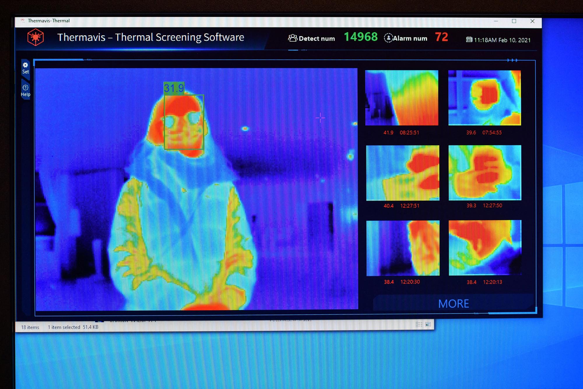 The results of a a thermal imaging camera are displayed on a screen as a person waits at the reception desk at the St Giles Hotel near Heathrow Airport in west London, on February 10, 2021. The Hotel has offered to become one of England's designated Covid-19 quarantine hotels. Health Secretary Matt Hancock told parliament that British or Irish residents arriving from 33 countries deemed high risk of new variants will have to stay in one of 16 designated hotels in England. Travellers will have to stay in their rooms, have meals delivered to them and pay out their own pocket. (Photo by Ben STANSALL / AFP)