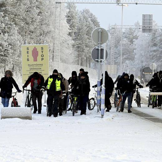Finnish border guards and migrants with bicycles are pictured at the international border crossing at Salla, Finnish Lapland on November 21, 2023. Most migrants are now arriving to the northern border stations between Finland and Russia since Finland on Saturday, November 18, 2023 closed four southernmost crossing points on its eastern border because of flow of third country migrants via Russia. Helsinki shut four of its crossings, claiming Moscow was seeking to destabilise Finland by letting undocumented migrants cross into the Nordic country. (Photo by Jussi Nukari / Lehtikuva / AFP) / Finland OUT